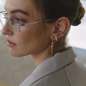 Close-up of 18K gold plated cuff earrings and tassel earrings with cubic zirconia on model