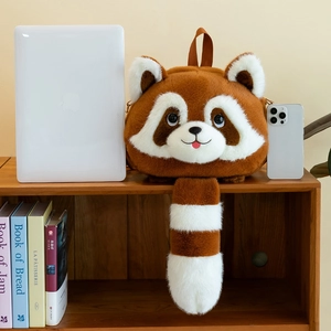Cute brown plush red panda backpack shown next to a laptop for size comparison