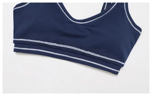 Detail of dark blue yoga top showing contrast white double-needle stitching and fabric texture