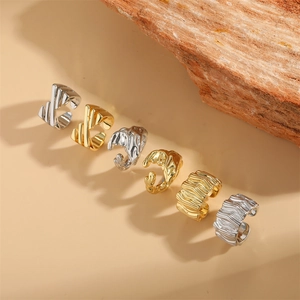 Set of 6 textured ear cuffs in gold and silver finish on a minimalist stone background