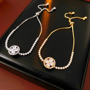 Detail of adjustable zircon clover bracelets in gold and silver with drawstring clasp