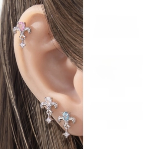 Detailed view of iris fleur-de-lis ear studs with colorful zircon stones on model