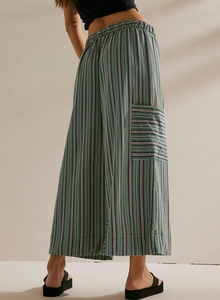 Detail of green striped wide leg pants featuring side pocket and vertical stripe texture