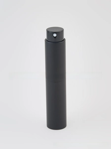 Detail view of a matte black portable perfume spray bottle with minimalist push nozzle