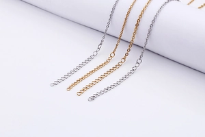Detail of four thin gold and silver curb chains for DIY jewelry making and necklace extensions