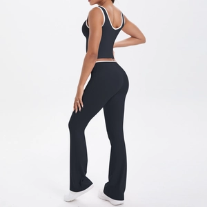 Détail du pantalon de yoga évasé à taille haute avec liseré blanc contrastant sur tissu noir