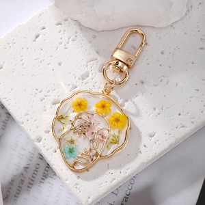 Face line art keychain with real dried flowers in gold resin frame on white stone