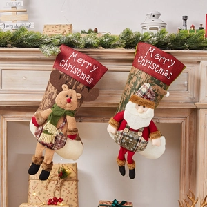 Christmas stockings with Santa and reindeer dolls hanging on a festive fireplace mantel