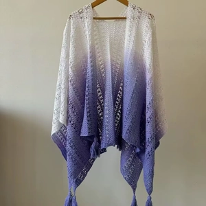 Detailed macro view of white to purple gradient knit shawl with delicate fringe tassels
