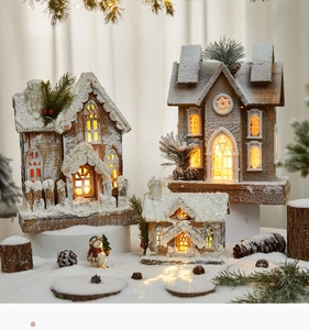 Close-up of lighted wooden Christmas house with snow texture and pine cone detail