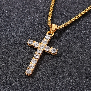 Gros plan d'un pendentif croix en or serti de strass avec une chaîne pour homme