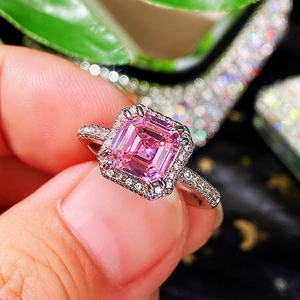 Macro shot of silver ring featuring emerald-cut pink gemstone with micro-pave diamonds