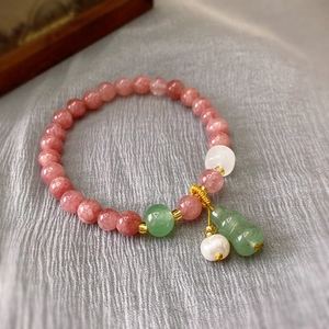 Detail of pink strawberry crystal bracelet with green gourd charm and white pearls
