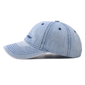 Détail d'une casquette en denim bleu clair montrant les coutures et la broderie
