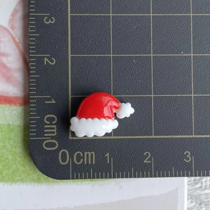 Detailed size view of a 1.5cm mini resin Christmas hat accessory on a measuring scale