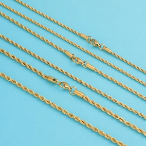 Tres cadenas de cordón de acero inoxidable dorado con cierres de langosta sobre azul