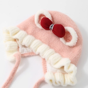 Soft pink plush baby girl winter earflap hat with a cute red bow and frill detail