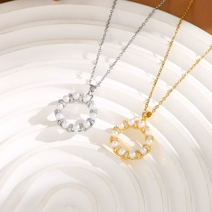 Macro detail of silver and gold necklaces with round pearl and rhinestone wreath pendants