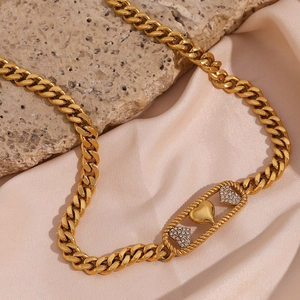 Vue détaillée du collier gourmette plaqué or avec ovale évidé et trois motifs cœurs