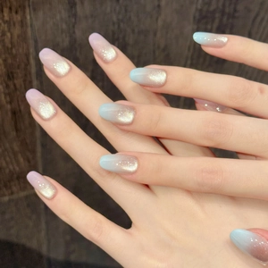 Pink and blue gradient oval press-on nails with champagne gold shimmer and cat-eye finish