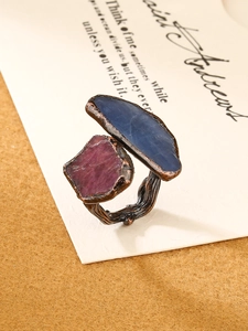 Detailed shot of bronze branch-textured ring featuring dual raw blue and purple gemstones