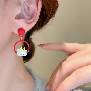 Gros plan de boucles d'oreilles cerf rouges avec bois jaunes portées par un mannequin