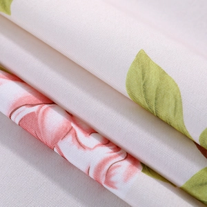 Close-up of linen fabric with pink floral patterns and high-quality woven texture