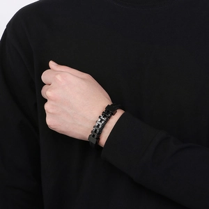 Dettaglio del bracciale intrecciato nero da uomo con chiusura metallica stile punk