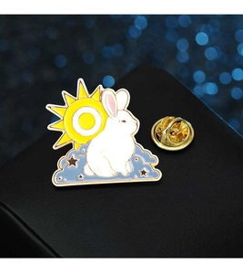Detail shot of a rabbit badge with sun and moon clouds on a dark textured background
