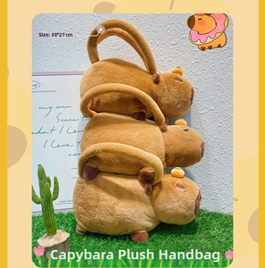 Detail of plush Capybara bag with orange accessory on artificial grass background