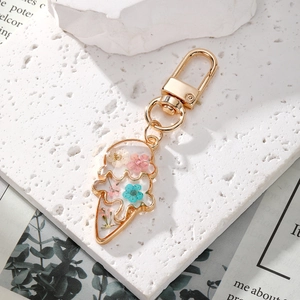 Ice cream shaped gold keychain with colorful real dried flowers on white stone