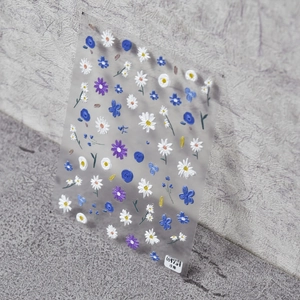 Macro detail of 5D embossed blue wildflower nail art stickers with relief texture