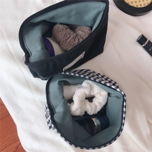 Detail of checkered and black canvas pouches showing green lining and storage capacity