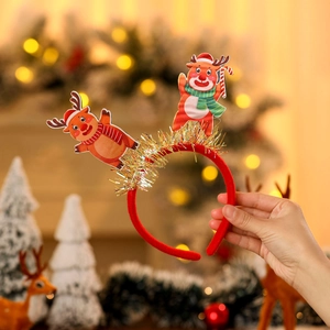 Détail d'un serre-tête de Noël avec guirlandes dorées et décoration de rennes mignons