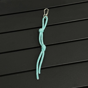 Close-up of light blue braided paracord keychain with metal spring buckle and knots