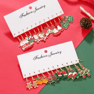 Detail of Christmas stud earrings set featuring snowflake and santa claus on festive cards