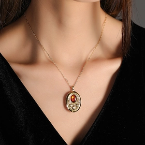 Dettaglio di collana vintage dorata con pietra ambra indossata da una modella