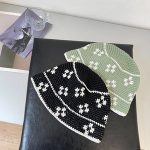 Handmade crochet bucket hat in black and sage green with delicate white floral patterns