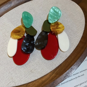 Detailed shot of retro acrylic marble teardrop earrings on a minimalist wooden tray