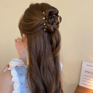 Brown hair claw clip with bear accent and rhinestones on hair of woman in back view