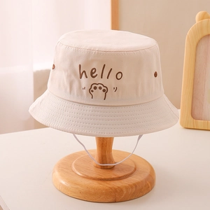 Detail of beige cotton bucket hat featuring hello embroidery and cute cat paw design