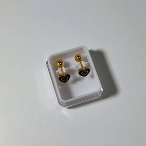 Macro shot of 18k gold heart stud earrings with black enamel and screw ball backs