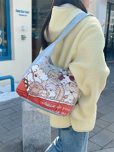 Blue canvas tote bag with cartoon bear prints and red bottom detail shown on model