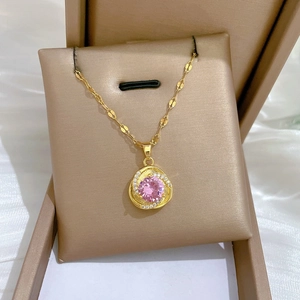 Detail of gold-plated necklace with a pink zircon pendant and crystal accents