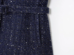 Dettaglio del tessuto tweed blu scuro con paillettes dorate e cintura coordinata