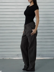 Side view of woman in black slim fit short sleeve athletic T-shirt and grey cargo pants