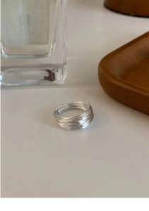 Close-up of a silver multi-layer layered winding ring with minimalist texture