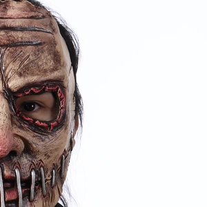 Close-up of stitched latex horror mask with metal studs and bloody seam details