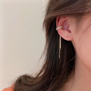 Detail of gold-plated tassel ear cuff with sparkling zircon stones worn on model's ear