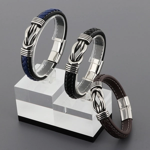 Detailed view of woven leather bracelets in navy, black, and brown with infinity knot metal clasp
